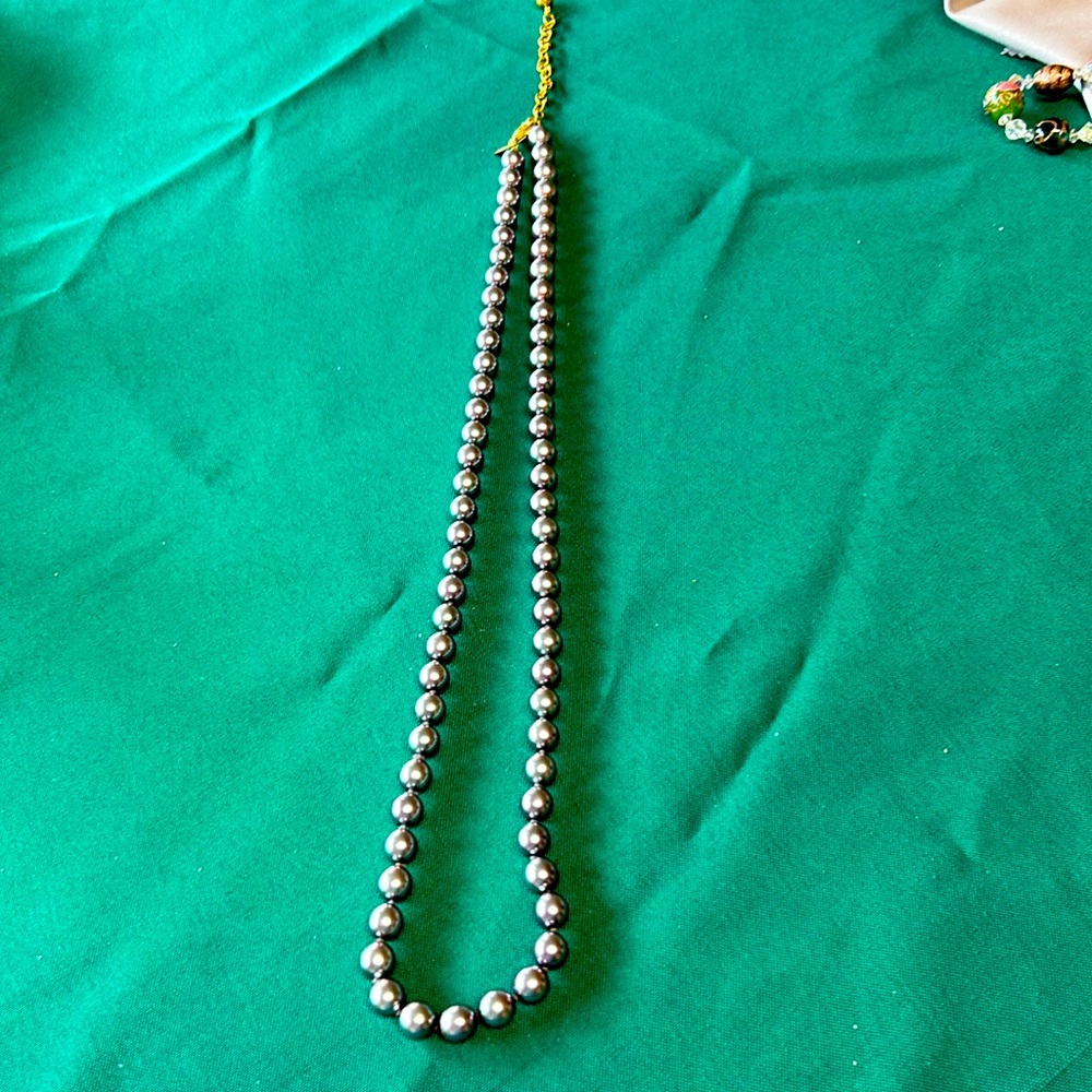 Silver tone strand of pearls.